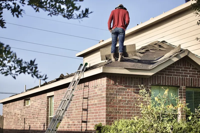 Professional roofer working on a residential roof in Windfall Heights